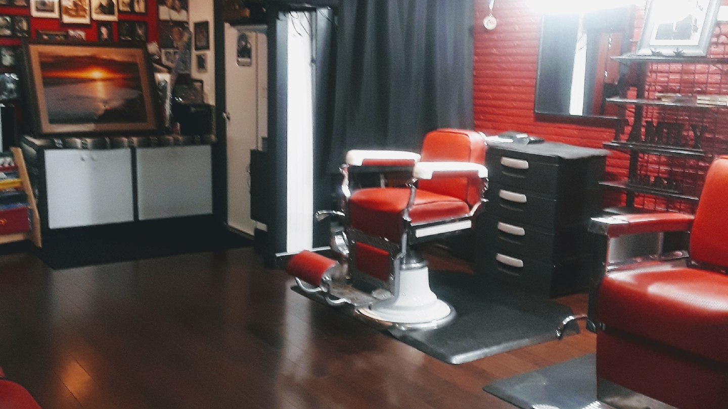 Vintage red-leather barber chairs and red brick wall inside Gloria Hair Salon in Rainier Valley, Seattle